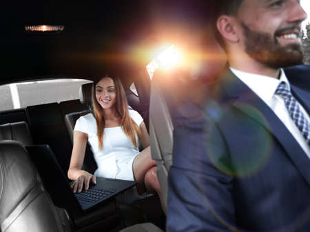 Executive businesswoman in car work on her laptop.の写真素材