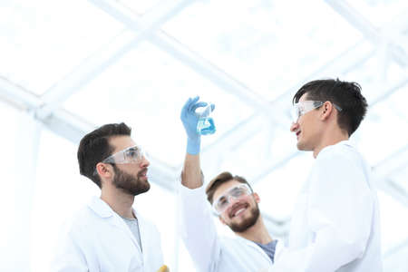 scientists studying the liquid in the beaker.の写真素材