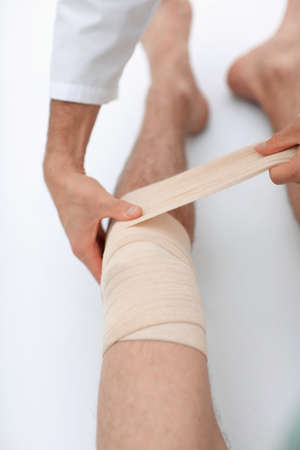 closeup. doctor bandaging a patients legの写真素材