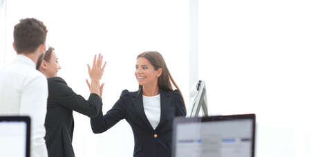 employees giving each other high five.の写真素材