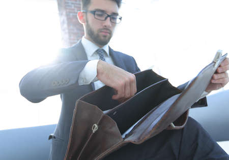 businessmans hand with suitecase in a modern officeの写真素材