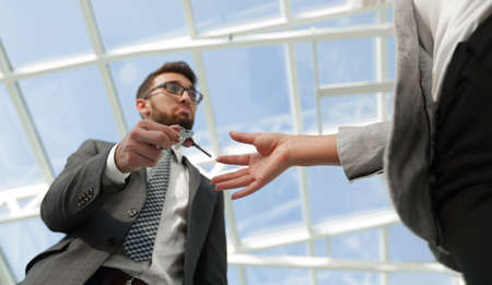 Cropped image of estate agent giving house keys to man in officeの写真素材