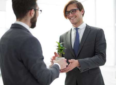 business partners are holding a young seedlingの写真素材