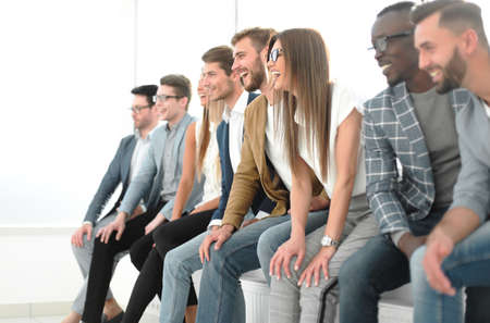 group of young professionals sitting near the wallの写真素材