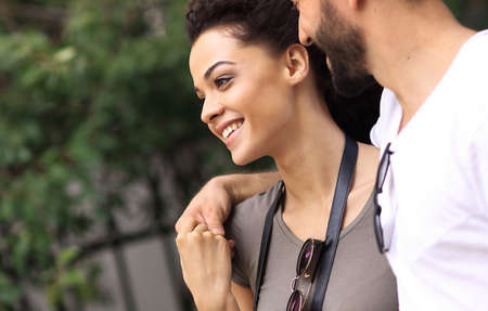 Cheerful young couple walking on urban street