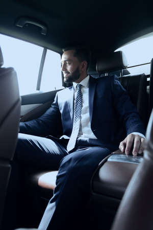 businessman sitting in the back seat of a carの写真素材