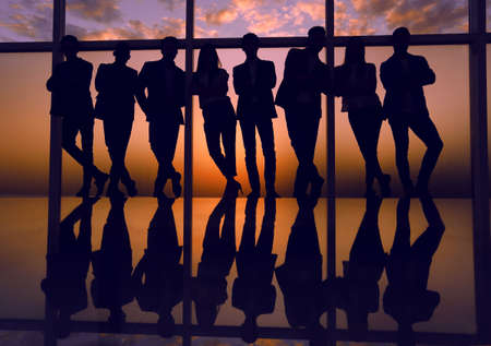 silhouette of a business team standing next to the office windowの写真素材