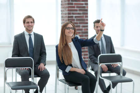 Confident young manager raising hand at workshopの写真素材