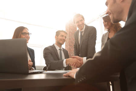 shaking hands after a business meeting in the office