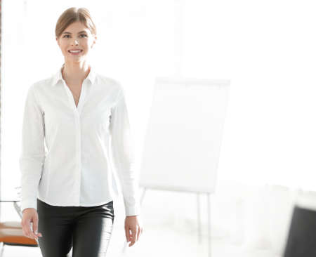 smiling young woman assistant is moving around the office.の写真素材