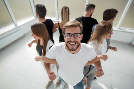 young man standing in a circle with a business teamの写真素材