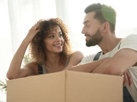 Portrait of the newlyweds near the box with things for moving.