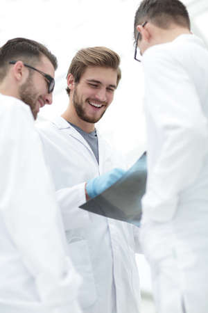 smiling doctors discussing x-ray with colleagues