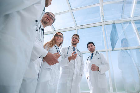 through the glass. group of doctors discussing current tasks