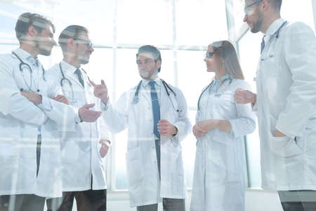 through the glass. a group of doctors standing in the office