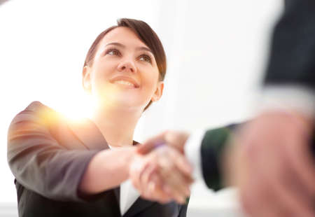 closeup of business woman shaking hands with her business partner.