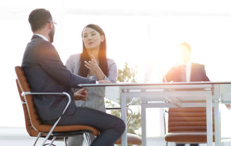 business colleagues talking, sitting behind a Deskの写真素材