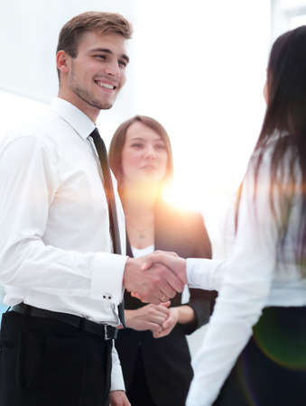 funny smiling businessman shaking hands with his partner.の写真素材