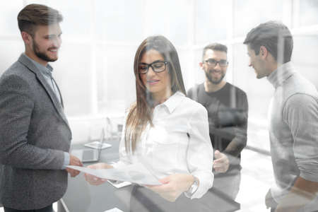 behind the glass.business team discusses working documentsの写真素材