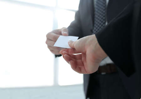 Close-up of two businesspeople exchanging visiting cardの写真素材