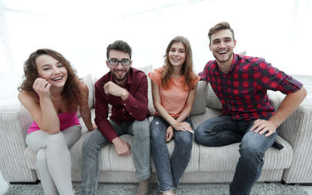 group of cheerful young people sitting on the couch.の写真素材