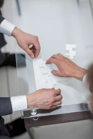 close up.business partners solving the puzzle
