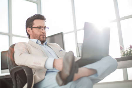 businessman using a laptop sitting at his Deskの写真素材