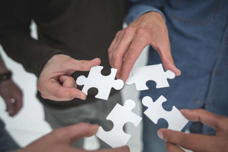 close up. pieces of the puzzle in the hands of young peopleの写真素材