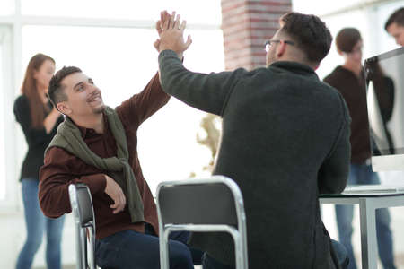 business colleagues giving each other high fiveの写真素材