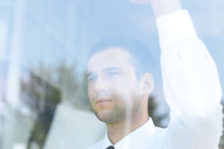 view from behind glass.confident businessman looking out the window of his office