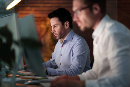 Businesspeople in the office at night working late