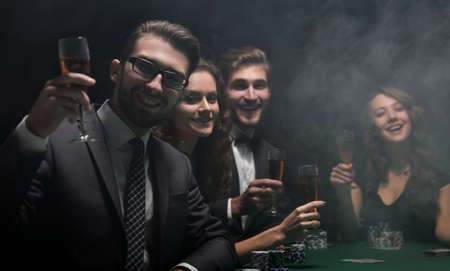 poker players with a glass of wine ,sitting at a table