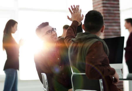 business colleagues giving each other high fiveの写真素材