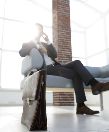Businessman sitting on sofa in the officeの写真素材