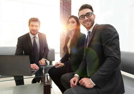 Smiling and confident business team sitting in front of a brightの写真素材