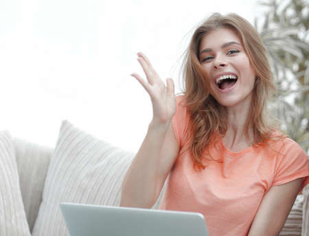 young couple rejoices,sitting on the couch in front of the open laptop