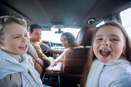 children sitting in the back seat of the carの写真素材