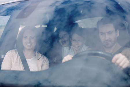 Family sitting in the car looking out windows