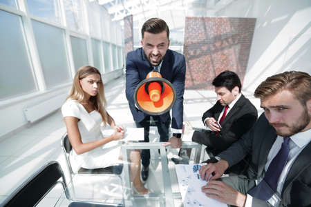 angry boss with megaphone at work meetingの写真素材