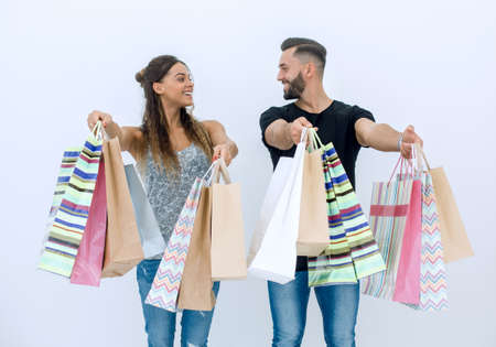 happy couple showing shopping bagsの写真素材