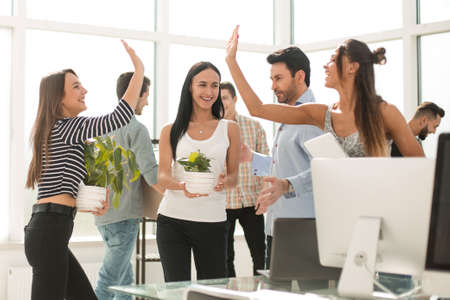 young group of office workers is moving to a new office
