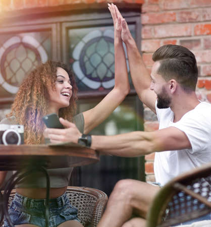 Portrait of a young  couple sitting down at a cafe terraceの写真素材