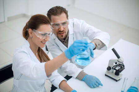 two chemists working with different liquids in tubesの写真素材