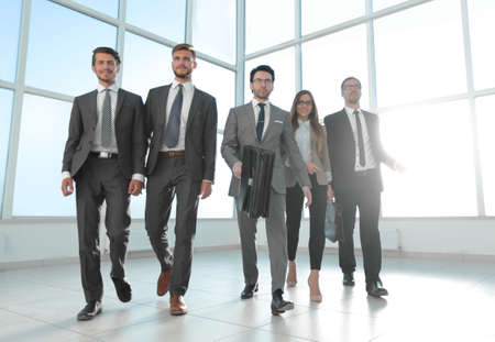 business people go down the hallway of a modern officeの写真素材