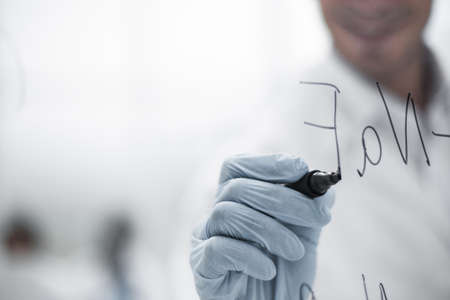 background image.scientist standing behind a glass Board.の写真素材