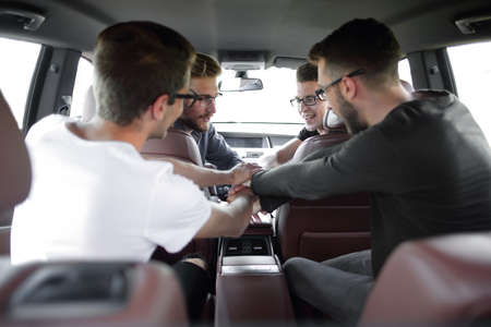 men greet colleagues before leaving by car.