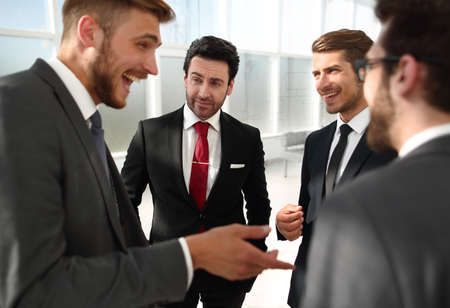 Manager and employees of the company talking standing in the officeの写真素材