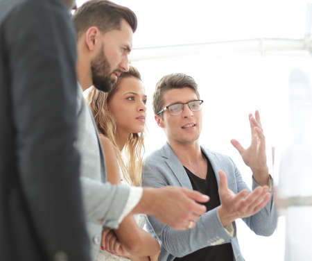 close up.business team talking, standing near the flipchartの写真素材