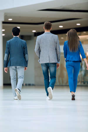 rear view.business colleagues walk in the office hall