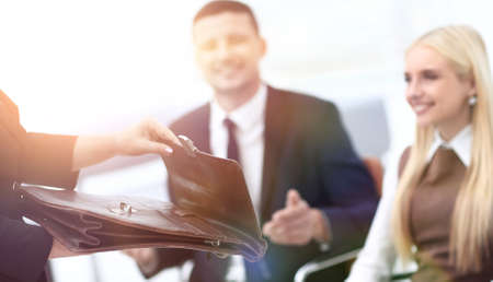 closeup of a lawyer opening briefcase with documents